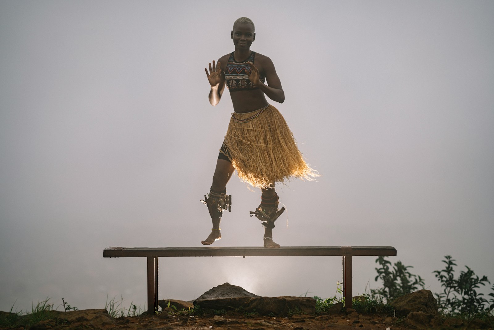 A traditional dancer mid-performance, backlit against a misty sky